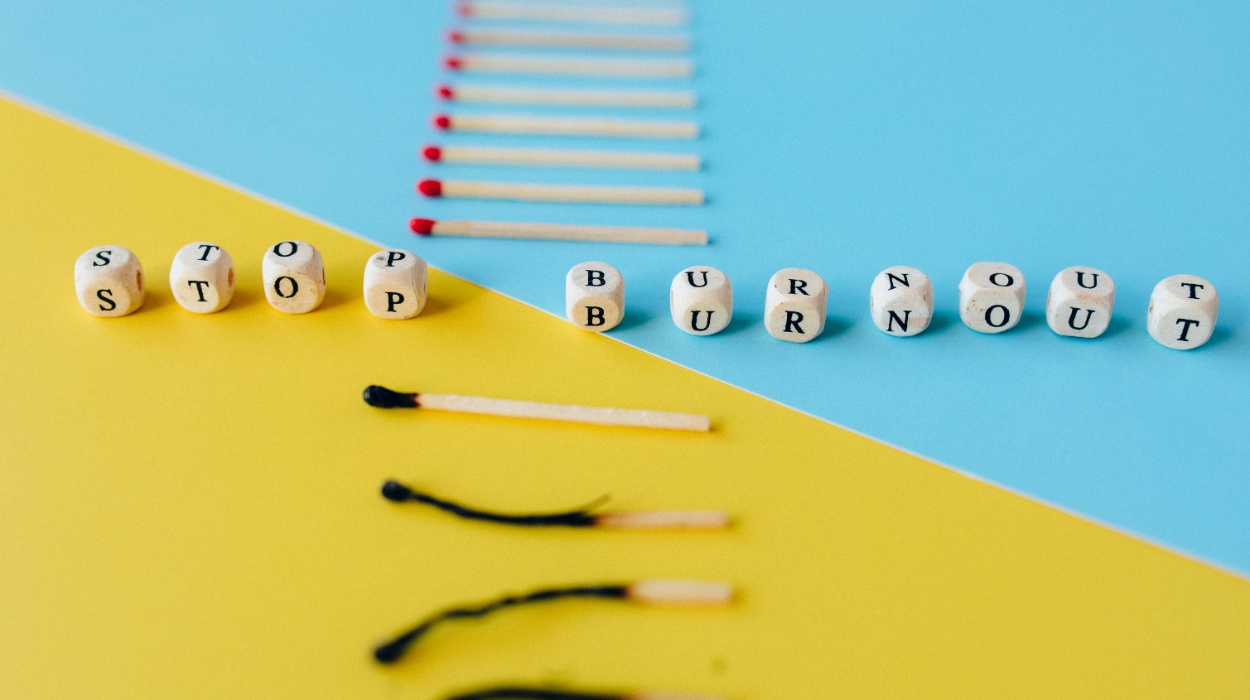 Beads spelling out "stop burnout" set alongside a row of matches, some burnt and some unlit