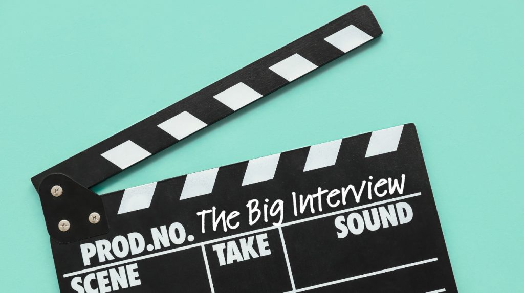 Movie scene clapper with "The Big Interview" written in the space for "production name"