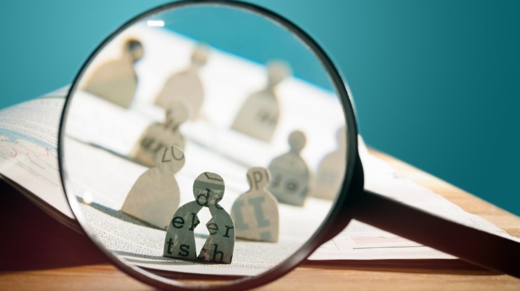 magnifying glass focusing on paper cut-out people